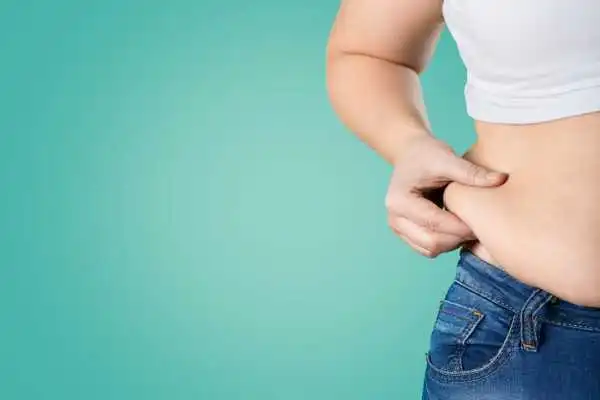 Image of woman pinching her love handles to show weight gain Middleton Park